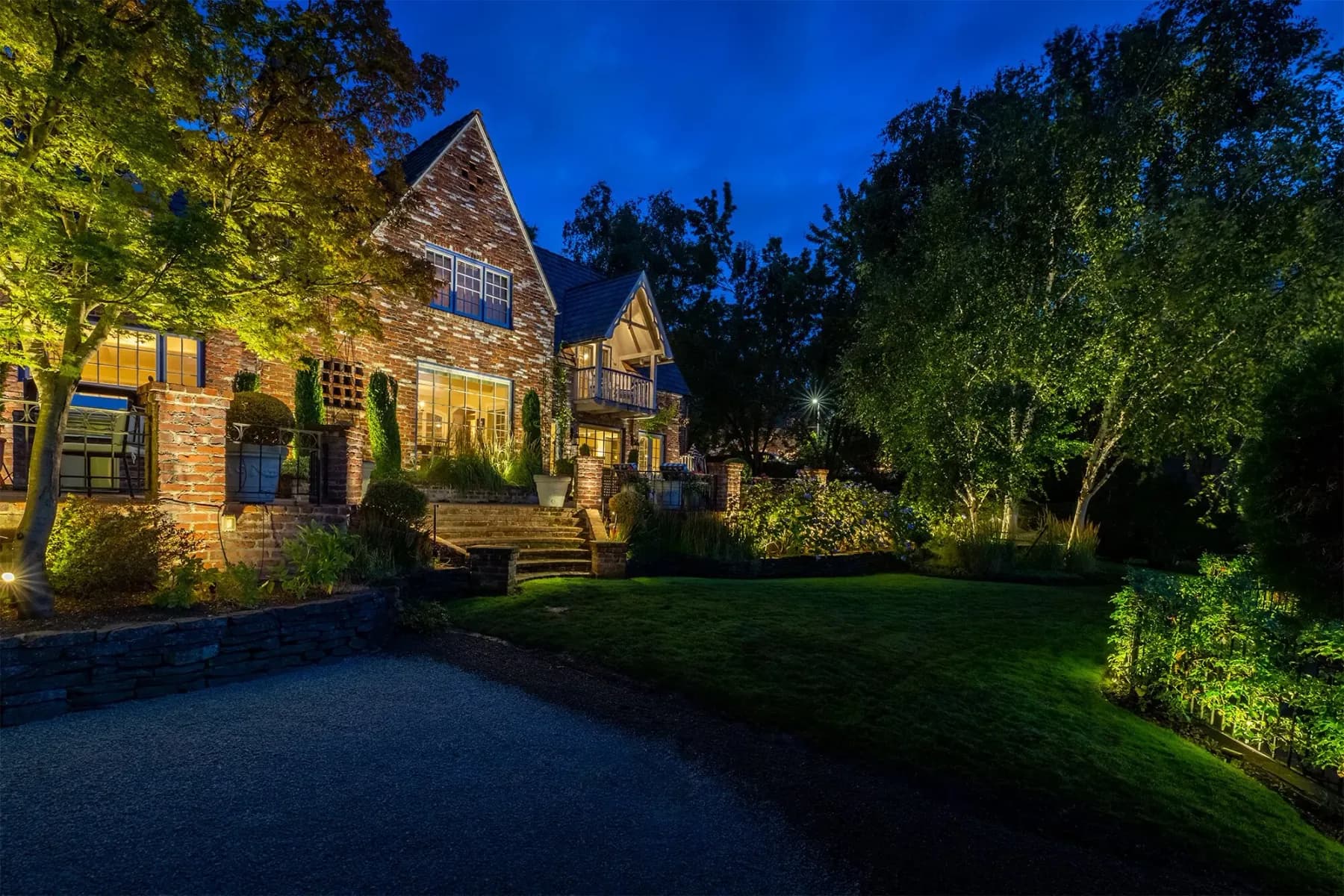 Home with outdoor lighting installed, lit at night